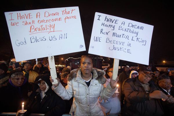 A woman holds up signs during a candlelight vigil at the site where Eric Garner died in July last year after being put in a chokehold, during a Martin Luther King Day service in the Staten Island borough of New York - Sputnik International