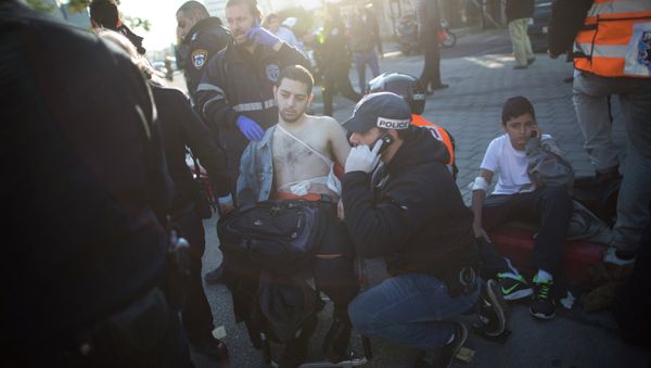 An Israeli police officer and paramedics treat an injured man at the scene of a stabbing in Tel Aviv, Israel An Israeli police officer and paramedics treat an injured man at the scene of a stabbing in Tel Aviv, Israel - Sputnik International