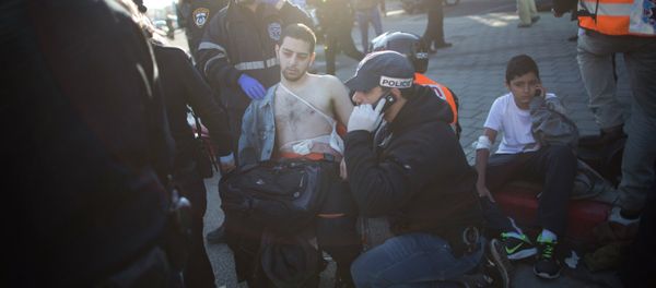 An Israeli police officer and paramedics treat an injured man at the scene of a stabbing in Tel Aviv, Israel An Israeli police officer and paramedics treat an injured man at the scene of a stabbing in Tel Aviv, Israel - Sputnik International