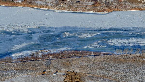 Crews work to contain an oil spill from Bridger Pipeline's broken pipeline near Glendive, Mont., in this aerial view showing both sides of the river - Sputnik International