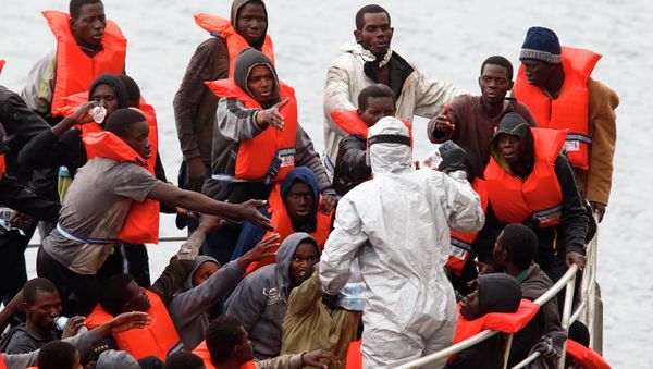 Rescued migrants on the deck of an Armed Forces of Malta (AFM) patrol boat reach out for bottles of water being distributed by a soldier in a biohazard suit after arriving at the AFM's Maritime Squadron base at Haywharf in Valletta's Marsamxett Harbour, January 22, 2015 - Sputnik International