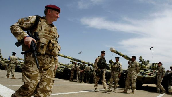 A British army soldier walks past Iraqi army tanks during a training mission in Latifiyah, 30 kilometers (20 miles) south of Baghdad, Iraq - Sputnik International