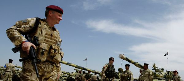 A British army soldier walks past Iraqi army tanks during a training mission in Latifiyah, 30 kilometers (20 miles) south of Baghdad, Iraq - Sputnik International