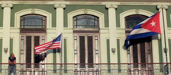 A man stands near the national flags of the U.S. and Cuba (R) on the balcony of a hotel being used by the first U.S. congressional delegation to Cuba since the change of policy announced by U.S. President Barack Obama on December 17, in Havana A man stands near the national flags of the U.S. and Cuba (R) on the balcony of a hotel being used by the first U.S. congressional delegation to Cuba since the change of policy announced by U.S. President Barack Obama on December 17, in Havana - Sputnik International
