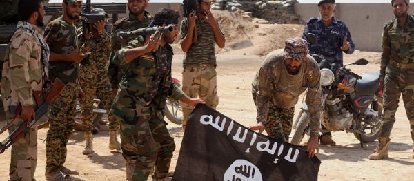 Iraqi security forces hold a flag of the Islamic State group they captured during an operation outside Amirli, some 105 miles (170 kilometers) north of Baghdad, Iraq - Sputnik International