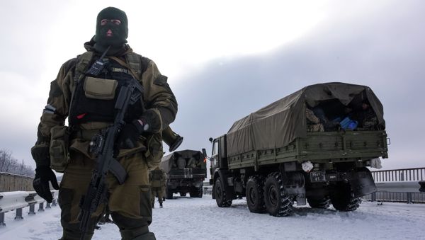 A soldier guards the road near the airport of Donetsk, with Ukrainian military vehicles at rear, Eastern Ukraine, Tuesday, Jan. 6, 2015 A soldier guards the road near the airport of Donetsk, with Ukrainian military vehicles at rear, Eastern Ukraine, Tuesday, Jan. 6, 2015 - Sputnik International