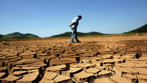 A worker from the Sao Paulo state company that provides water and sewage services to residential, commercial and industrial areas looks at the cracked ground of near Jaguary dam in Braganca Paulista, 100 km from Sao Paulo, in this file photo taken January 31, 2014 A worker from the Sao Paulo state company that provides water and sewage services to residential, commercial and industrial areas looks at the cracked ground of near Jaguary dam in Braganca Paulista, 100 km from Sao Paulo, in this file photo taken January 31, 2014 - Sputnik International