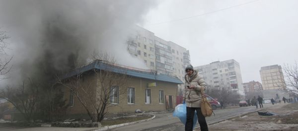 A woman resident passes by a burning house in Mariupol, Ukraine, Saturday, Jan. 24, 2015 A woman resident passes by a burning house in Mariupol, Ukraine, Saturday, Jan. 24, 2015 - Sputnik International