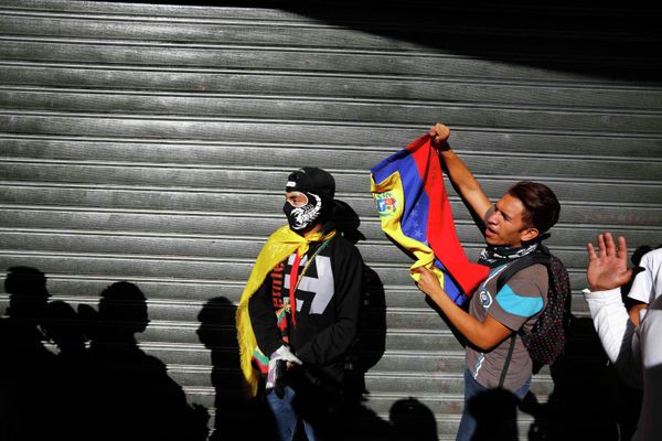 Demonstrators who support the opposition shouts slogans near people who were lining outside a supermarket to buy basic goods when it closed shortly for the day due to the ongoing protest in Caracas January 24, 2015 - Sputnik International