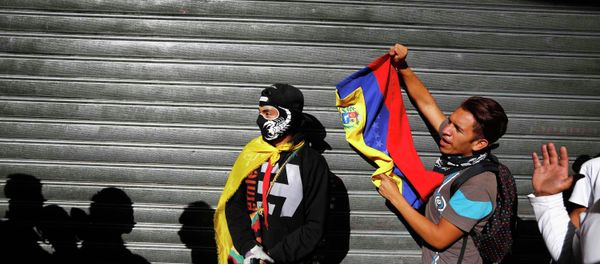 Demonstrators who support the opposition shouts slogans near people who were lining outside a supermarket to buy basic goods when it closed shortly for the day due to the ongoing protest in Caracas January 24, 2015 - Sputnik International