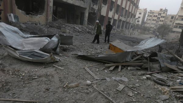 Residents inspect a damaged site after what activists said were air strikes by forces loyal to Syria's President Bashar al-Assad in Douma eastern Al-Ghouta, near Damascus January 25, 2015 - Sputnik International