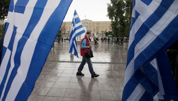 A man holding a Greek flag walks on central Syntagma square as the parliament is seen in the background, in Athens January 24, 2015 A man holding a Greek flag walks on central Syntagma square as the parliament is seen in the background, in Athens January 24, 2015 - Sputnik International