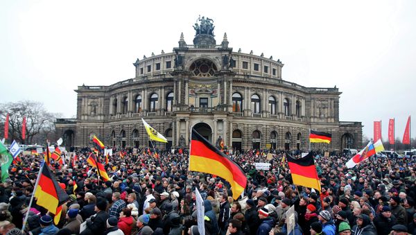 Members of the movement of Patriotic Europeans Against the Islamisation of the West (PEGIDA) hold flags and banners during a PEGIDA demonstration march in Dresden Members of the movement of Patriotic Europeans Against the Islamisation of the West (PEGIDA) hold flags and banners during a PEGIDA demonstration march in Dresden - Sputnik International