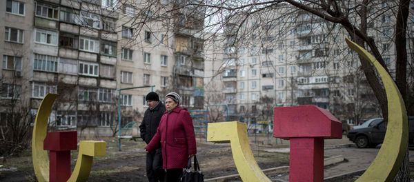 Local residents walk past Soviet-era hammer and sickle sculptures outside an apartment building damaged after Saturday's shellingin Mariupol, Ukraine Local residents walk past Soviet-era hammer and sickle sculptures outside an apartment building damaged after Saturday's shellingin Mariupol, Ukraine - Sputnik International