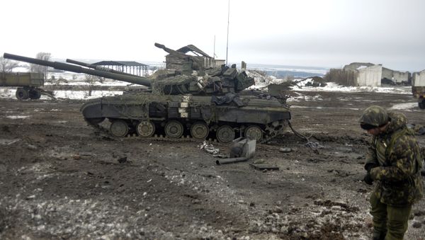 A Ukrainian soldier examines a crater after shelling near Debaltseve, in the Donetsk region - Sputnik International