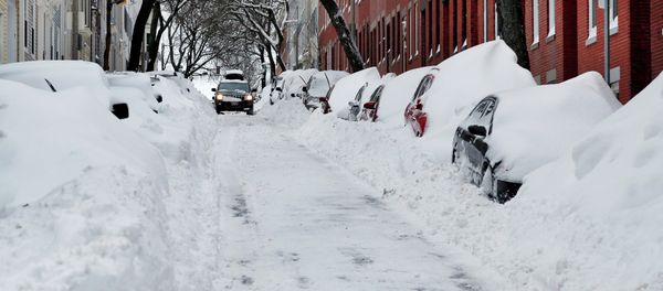 A car makes its way down a street filled with snowed-in vehicles in Boston's Charlestown section, Wednesday, Jan. 28, 2015 one day after a blizzard dumped about two feet of snow in the city - Sputnik International