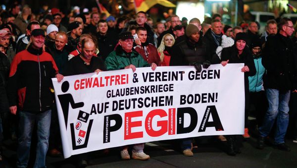 Participants hold a banner during a demonstration called by anti-immigration group PEGIDA, a German abbreviation for Patriotic Europeans against the Islamization of the West, in Dresden December 15, 2014 Participants hold a banner during a demonstration called by anti-immigration group PEGIDA, a German abbreviation for Patriotic Europeans against the Islamization of the West, in Dresden December 15, 2014 - Sputnik International