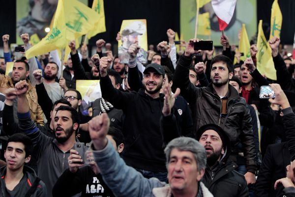 Hezbollah supporters raise their hands in salute as their leader Sheikh Hassan Nasrallah - Sputnik International