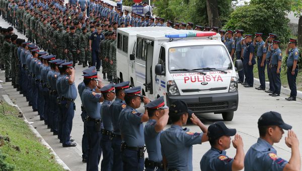 Philippine National Police salute for the final sendoff as a van with one of the remains of 44 special commandos leaves Camp Bagong Diwa for its final journey to his hometown Saturday, Jan. 31, 2015 at suburban Taguig city, south of Manila, Philippines - Sputnik International