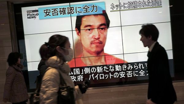 People walk by a screen showing TV news reports of Japanese hostage Kenji Goto, held by the Islamic State group, in Tokyo Saturday, Jan. 31, 2015 People walk by a screen showing TV news reports of Japanese hostage Kenji Goto, held by the Islamic State group, in Tokyo Saturday, Jan. 31, 2015 - Sputnik International