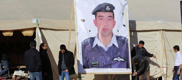 Relatives of Islamic State captive Jordanian pilot Muath al-Kasaesbeh place a poster of him in front of their new gathering headquarters in Amman January 30, 2015 - Sputnik International
