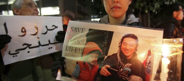 A protester holding a photo of Japanese journalist Kenji Goto who was taken hostage by the Islamic State group - Sputnik International