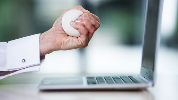 Business woman squeezing stress ball over desk, close-up  - Sputnik International