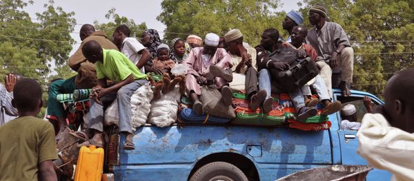 Villagers sit on the back of a small truck as they and others flee the recent violence near the city of Maiduguri, Nigeria Villagers sit on the back of a small truck as they and others flee the recent violence near the city of Maiduguri, Nigeria - Sputnik International