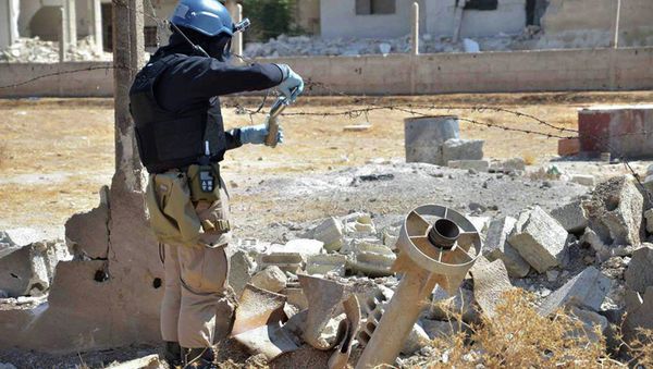 Member of UN investigation team taking samples of sands near a part of a missile that is likely to be one of the chemical rockets according to activists, in Damascus countryside of Ain Terma, Syria Member of UN investigation team taking samples of sands near a part of a missile that is likely to be one of the chemical rockets according to activists, in Damascus countryside of Ain Terma, Syria - Sputnik International