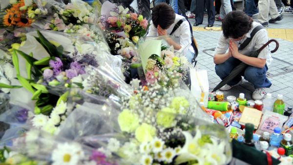 Two men offer prayer for victims of Sunday's knifing rampage in which seven people were stabbed to death at Tokyo's Akihabara shopping district - Sputnik International