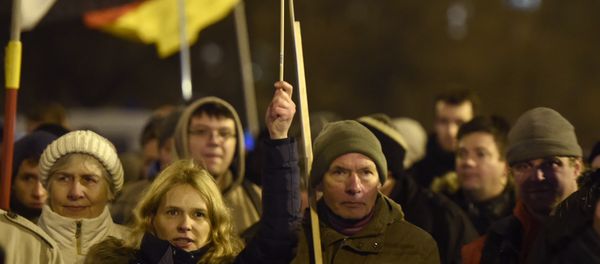 Anti-Islam protesters hold German flags during a BERGIDA rally, a local copycat of Dresden's right-wing populist movement PEGIDA (Patriotic Europeans Against the Islamisation of the Occident), at Alexander Platz in Berlin, eastern Germany - Sputnik International