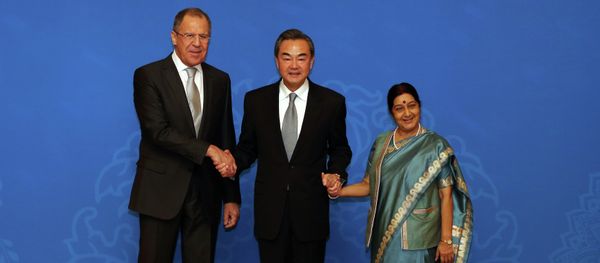 Russian Foreign Minister Sergei Lavrov (L), Chinese Foreign Minister Wang Yi (C) and Indian Foreign Minister Sushma Swaraj (R) shake hands as they for photographs before the thirteenth meeting of the Foreign Ministers of the China, Russia and India in Beijing on February 2, 2015 Russian Foreign Minister Sergei Lavrov (L), Chinese Foreign Minister Wang Yi (C) and Indian Foreign Minister Sushma Swaraj (R) shake hands as they for photographs before the thirteenth meeting of the Foreign Ministers of the China, Russia and India in Beijing on February 2, 2015 - Sputnik International