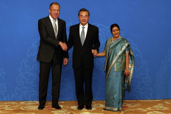 Russian Foreign Minister Sergei Lavrov (L), Chinese Foreign Minister Wang Yi (C) and Indian Foreign Minister Sushma Swaraj (R) shake hands as they for photographs before the thirteenth meeting of the Foreign Ministers of the China, Russia and India in Beijing on February 2, 2015 - Sputnik International