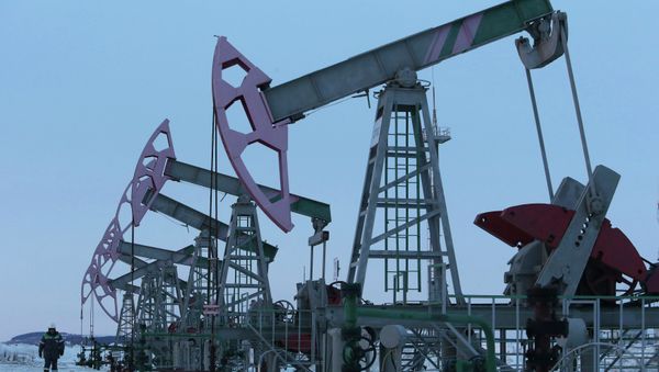A worker walks past pump jacks on an oil field owned by Bashneft company near the village of Nikolo-Berezovka, northwest from Ufa, Bashkortostan, January 28, 2015 - Sputnik International