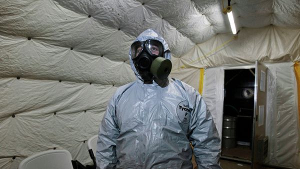 A marine officer of the Cape Ray, a ship equipped to neutralize Syrian chemicals, shows a chemical protection suit to reporters - Sputnik International