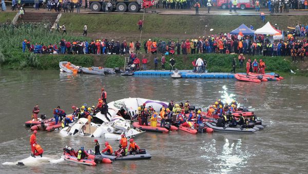 Rescue personnel search for passengers from the wreckage of a TransAsia ATR 72-600 turboprop plane that crash-landed into the Keelung river outside Taiwan's capital Taipei in New Taipei City on February 4, 2015. - Sputnik International