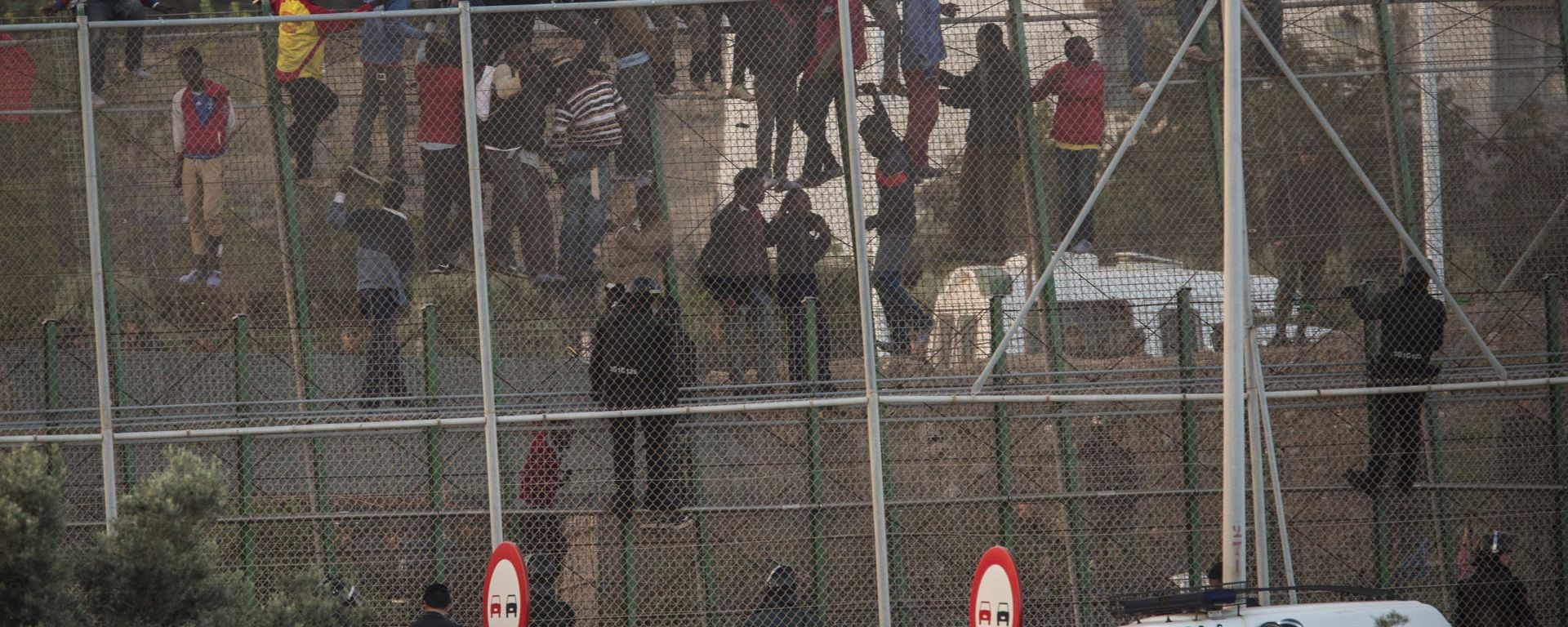 Sub-Saharan migrants sit on a metal fence that divides Morocco and the Spanish enclave of Melilla - Sputnik International, 1920, 25.06.2022