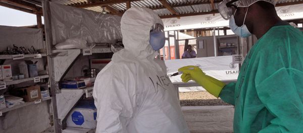 A health care worker assists a collegue inside a USAID, funded Ebola clinic in Monrovia, Liberia, Friday, Jan. 30, 2015. The World Health Organization says officials are now focused on ending the biggest-ever Ebola outbreak rather than just slowing the virus’ spread. In an update published Thursday, Jan. 29, 2015, the U.N. health agency said the three most affected countries _ Guinea, Sierra Leone and Liberia _ reported fewer than 100 cases in the past week, for the first time since June, 2014. - Sputnik International