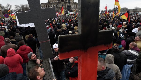 Demonstrators show crosses during a rally of the group Patriotic Europeans against the Islamisation of the West, or PEGIDA Demonstrators show crosses during a rally of the group Patriotic Europeans against the Islamisation of the West, or PEGIDA - Sputnik International