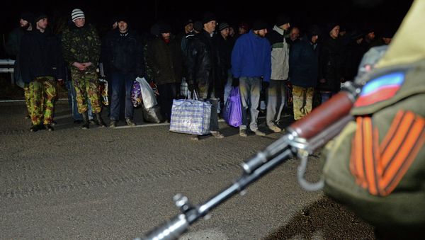 Ukrainian prisoners stand as a militant of the self-proclaimed People's Republic of Donetsk stands guard during a prisoner exchange with Ukraine on December 26, 2014. File photo Ukrainian prisoners stand as a militant of the self-proclaimed People's Republic of Donetsk stands guard during a prisoner exchange with Ukraine on December 26, 2014. File photo - Sputnik International
