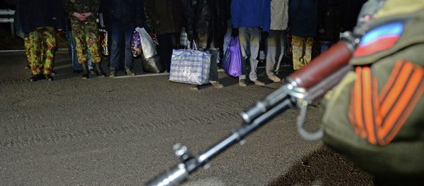 Ukrainian prisoners stand as a militant of the self-proclaimed People's Republic of Donetsk stands guard during a prisoner exchange with Ukraine on December 26, 2014. File photo Ukrainian prisoners stand as a militant of the self-proclaimed People's Republic of Donetsk stands guard during a prisoner exchange with Ukraine on December 26, 2014. File photo - Sputnik International