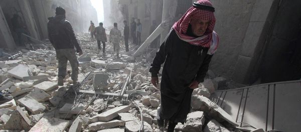 A man walks on debris as blood covers rubble of damaged buildings, at a site hit by what activists said was a barrel bomb dropped by forces loyal to Syria's President Bashar al-Assad, in the al-Myassar neighbourhood of Aleppo - Sputnik International