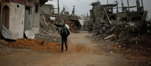 A PalestinianA Palestinian walks near the remains of houses, that witnesses said were destroyed or damaged by Israeli shelling during the July-August war between Israel and Hamas-led Gaza militants, in the east of Gaza City A PalestinianA Palestinian walks near the remains of houses, that witnesses said were destroyed or damaged by Israeli shelling during the July-August war between Israel and Hamas-led Gaza militants, in the east of Gaza City - Sputnik International