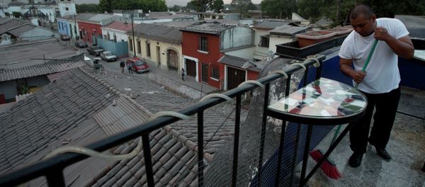 A waiter sweeps the ash covered terrace of a restaurant, from the eruption of the Fuego Volcano at Antigua Guatemala, Saturday, Feb. 7, 2015 - Sputnik International