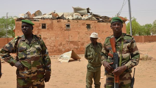 Nigerien soldiers stand near a damaged building in an army base in Agadez, northern Niger on May 26, 2013 Nigerien soldiers stand near a damaged building in an army base in Agadez, northern Niger on May 26, 2013 - Sputnik International
