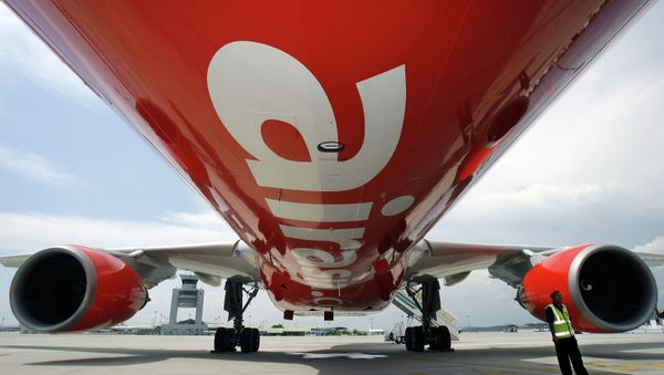 A security officer (R) stands by AirAsia X's first leased Airbus A330 long-haul aircraft as it sits on the tarmac of the Kuala Lumpur International Airport. File photo. - Sputnik International