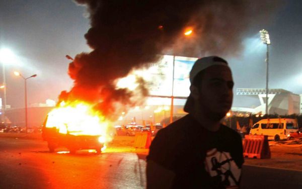 A soccer fan is seen near a police car, which was set on fire by fireworks, during clashes between soccer fans and security forces in front of a stadium on the outskirts of Cairo February 8, 2015 A soccer fan is seen near a police car, which was set on fire by fireworks, during clashes between soccer fans and security forces in front of a stadium on the outskirts of Cairo February 8, 2015 - Sputnik International