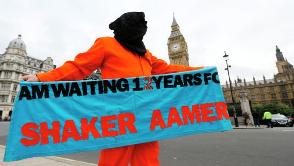 A protester holds up a banner during a protest against the Guantanamo Bay detention camp, in Parliament Square in London A protester holds up a banner during a protest against the Guantanamo Bay detention camp, in Parliament Square in London - Sputnik International