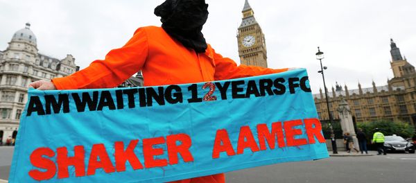 A protester holds up a banner during a protest against the Guantanamo Bay detention camp, in Parliament Square in London A protester holds up a banner during a protest against the Guantanamo Bay detention camp, in Parliament Square in London - Sputnik International