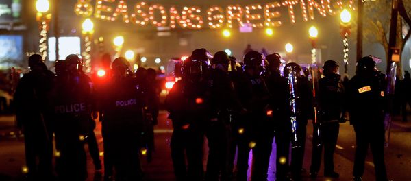 Police in riot gear use tear gas to clear the street in front of the Ferguson Police Department after the announcement of the grand jury decision not to indict police officer Darren Wilson in the fatal shooting of Michael Brown, an unarmed black 18-year-old, Monday, Nov. 24, 2014, in Ferguson, Mo. Police in riot gear use tear gas to clear the street in front of the Ferguson Police Department after the announcement of the grand jury decision not to indict police officer Darren Wilson in the fatal shooting of Michael Brown, an unarmed black 18-year-old, Monday, Nov. 24, 2014, in Ferguson, Mo. - Sputnik International
